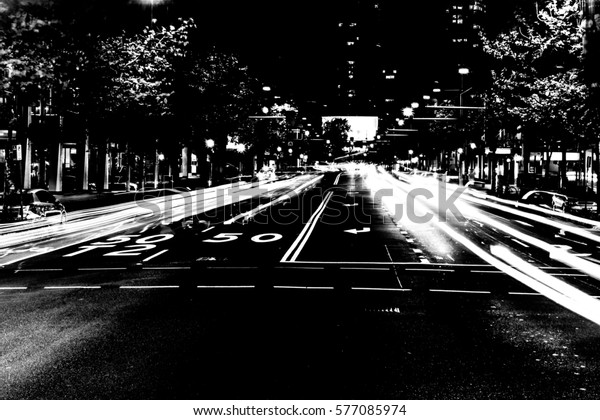 black and white photo of a street in Sydney with\
car lights in motion