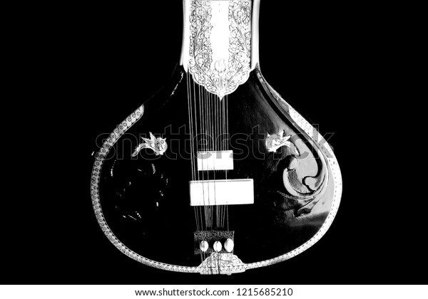 black and white photo of a stringed instrument from\
Indian classical music