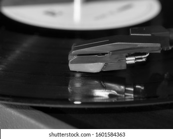 Black And White Photo Of Vintage Dj Turntables Needle Cartridge In Focus.Overhead Shot Of Dj Turntable Tone Arm.Professional Vintage Dj Audio Equipment Macro.Retro Hipster Vinyl Records Player Closeup