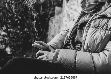 Black And White Photo Of A Woman Smoking Outside 