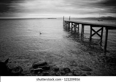 Black And White Photo Of The Wooden Jetty On A Lake Garda In Italy