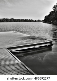 Black And White Photo Of Wooden Pier On Alum Lake 'Kamencove Jezero' In Chomutov City At The End Of The Summer Tourist Season