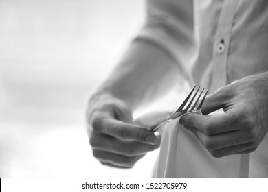 Black and white photo of young waiter cleaning fork in restaurant - Powered by Shutterstock