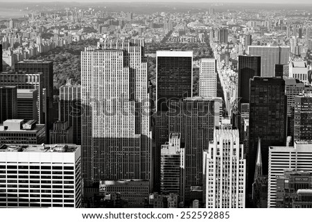 Black and White photograph of Midtown Manhattan with a view of Central Park and Upper Manhattan further back. Aerial view of Manhattan's skyscrapers and buildings, New York City.