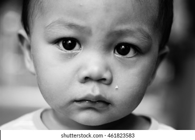 Black And White Photography Of An Asian Boy With Sad Face Looking At Camera