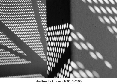 Black and white photography of modern architecture detail with shadows on the wall.