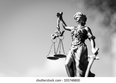 Black and white photography of sculpture of themis, femida or justice goddess on bright sky copy space background - Shutterstock ID 335748800
