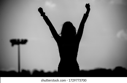 Black And White Photography. Silhouette Of A Girl With Raised Hands On The Football Field. Victory. Art Photography.