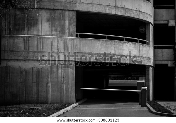 Black\
and white picture of a concrete parking lot exit\
