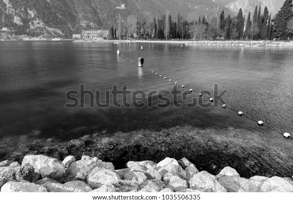 black and white picture of the\
lake with lots of reflection and buoys that divide the\
scenary