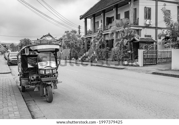 Black and white picture of an old tuk tuk rickshaw\
in Luang Prabang Laos.