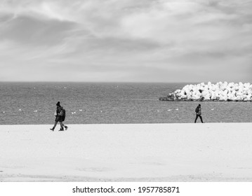 Black And White Picture With People Walking In Opposite Direction