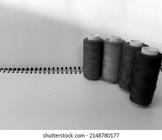 black and white picture purple, yellow, green, and blue sewing thread on a white background