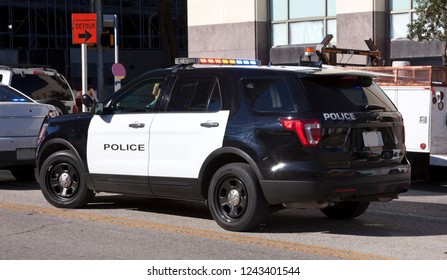 Black And White Police Suv Parked On City Street.