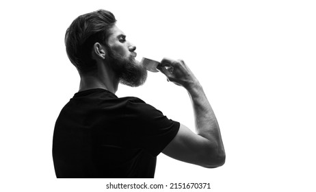 Black and white portrait of bearded man with hair brush on white. Trendy and stylish beard styling and cut. Brutal young bearded man. Stylish man brushing his beard and moustache - Shutterstock ID 2151670371