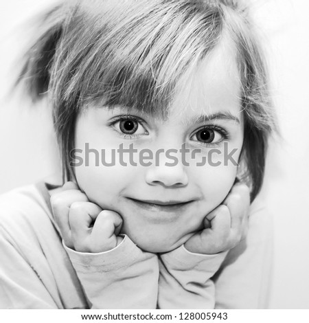 Black and white portrait of beautiful funny little girl. Selective focus on the eyes of a child. Retro style.