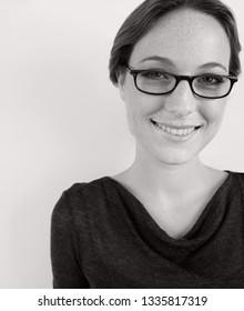 Black And White Portrait Of Beautiful Smiling Young Professional Woman Wearing Reading Glasses, Wall Space, Smiling Beauty, Lifestyle. Elegant Female Fun Expression With Spectacles, Quirky Face.