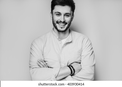 Black And White Portrait Of Handsome Smiling Man Isolated On Gray Studio Background Posing To The Camera