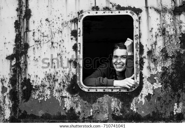 Black and white portrait of happy young woman in\
the window vintage train.