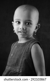 Black And White Portrait Of An Indian Girl Child With Shaved Head