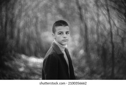 Black And White Portrait Of A Sad Boy Outside In Nature