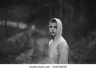 Black And White Portrait Of A Sad Boy Outside In Nature