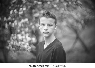 Black And White Portrait Of A Sad Boy Outside In Nature