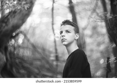 Black And White Portrait Of A Sad Boy Outside In Nature