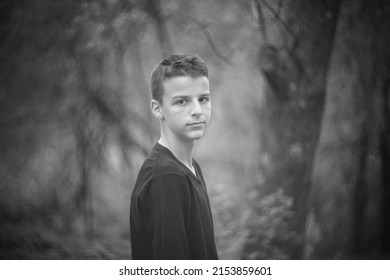 Black And White Portrait Of A Sad Boy Outside In Nature