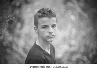 Black And White Portrait Of A Sad Boy Outside In Nature