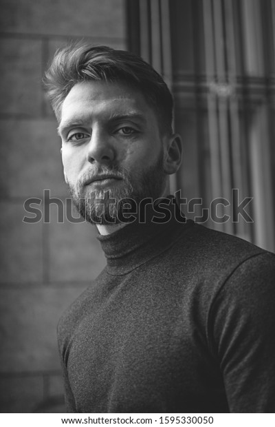 black\
and white portrait of a serious brutal man with beard and red hairs\
and green eyes and  scars after car catastrophe\
