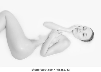 Black and white portrait of Sleeping beauty in spa. Sexy elegant woman with silk skin relaxing lying in milk on copy space background.