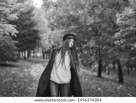 Similar – Junge Frau sitzt auf einer Bank in einem Park in ruhiger Pose.