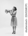 Black and white portrait of young beautiful woman shouting expressively in megaphone. Big sales, news. Concept of beauty, retro style, fashion, elegance, 60s, 70s, shout. Copy space for ad