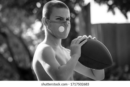 Black And White Portrait Of A Young Boy Playing American Football And Wearing A Face Mask To Prevent Covid 19 Exposure