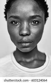 Black And White Portrait Of A Young Dark-skinned Woman With A Short Stitch, On A White Background