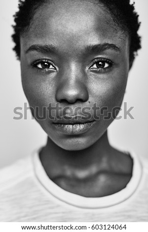 Black and white portrait of a young dark-skinned woman with a short stitch, on a white background