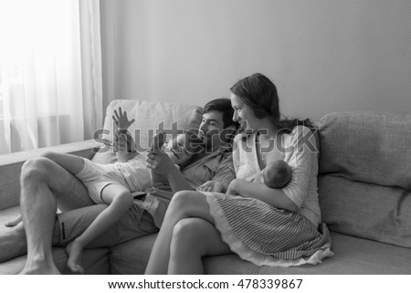 Similar – Mother reading book to her sons in the bed