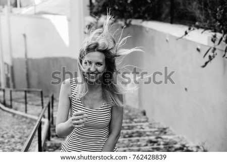 Similar – Young blonde woman portrait laughing outdoors sitting in a garden, and looking at camera.