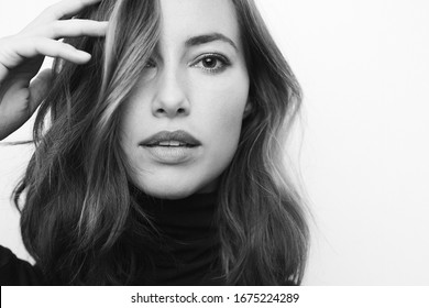 Black And White Portrait Of A Young Serious Woman Looking Directly In Camera With Stunning Eyes And A Fashionable And Model Face