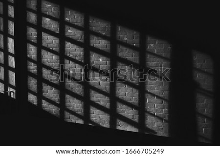 Black white quadratic shadow on a stonework wall illuminated by late sunlight - concept dramatic contrast film noir mystic interior texture background surface structure window close up detail evening