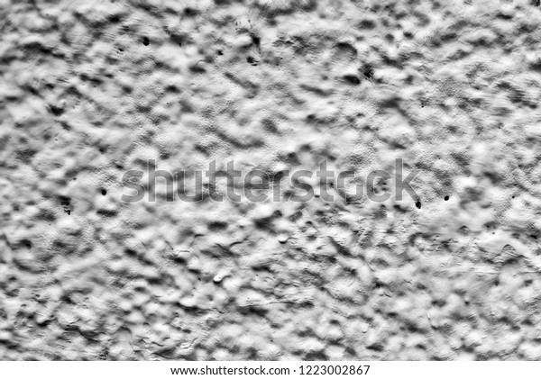 black\
and white relief wall of the house. Dirty shabby wall with putty.\
Relief paint black and white. The wall paint is like clouds and\
sky. View of the mountains and craters of the\
moon.