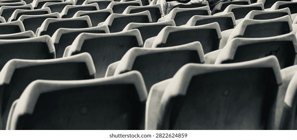 Black and white repeating pattern of vacant stadium seating rows