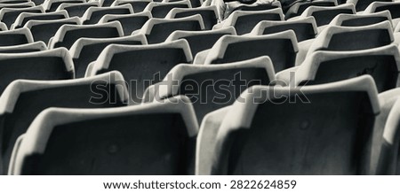 Black and white repeating pattern of vacant stadium seating rows