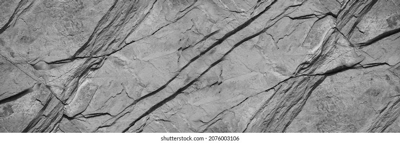 Black white rock texture. Mountain surface. Close-up. Gray stone background with copy space for design. Wide banner.	Panoramic.