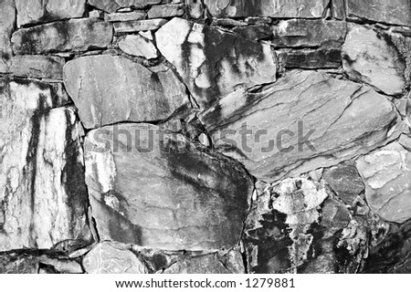 Black and white rocks together on a wall . Good for background .