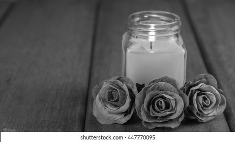 black and white roses  and Glass candle On the old wooden table condolence Background