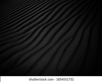Black and White Sand beach macro photography. Texture of black and whote sand for background. Close-up macro view of volcanic sand surface black and white color. 
