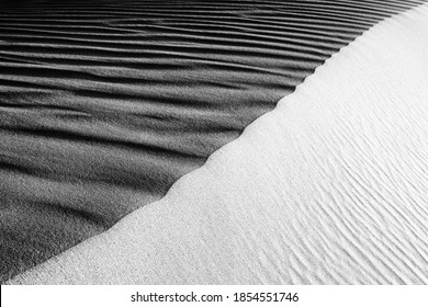 Black And White Sand Beach Macro Photography. Texture Of Black And Whote Sand For Background. Close-up Macro View Of Volcanic Sand Surface Black And White Color. 