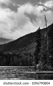 Black And White Scene Of A Father And Son Fishing On A Dock On The Lake